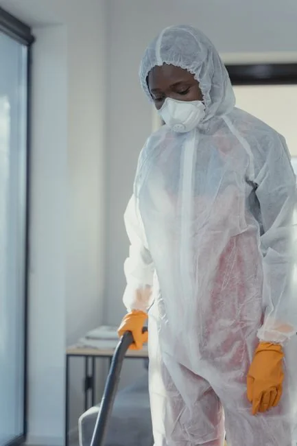 services-01 A person disinfects a work area by fumigation while wearing full protective equipment for protection.
